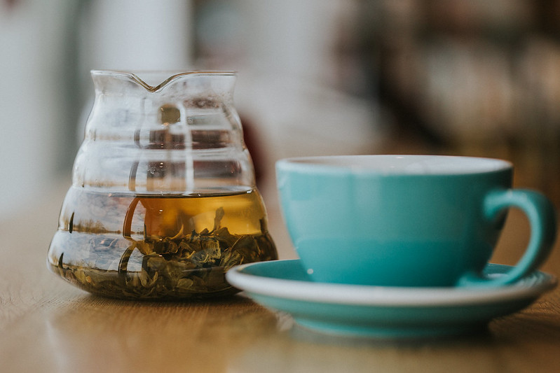 Filiżanka i dzbanek z herbatą liściastą 