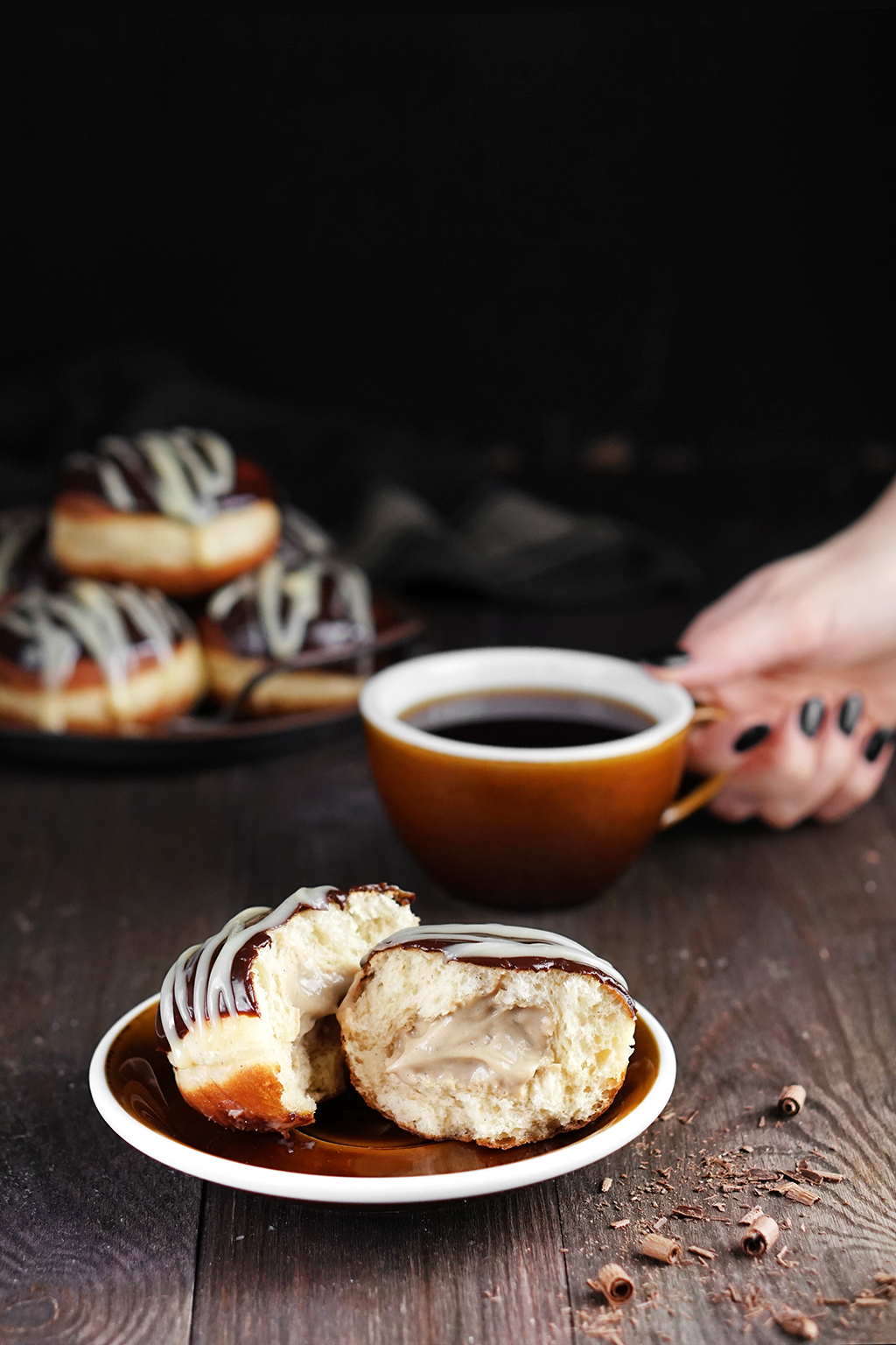 Pączek z nadzieniem kawowym oraz filiżanka czarnej kawy